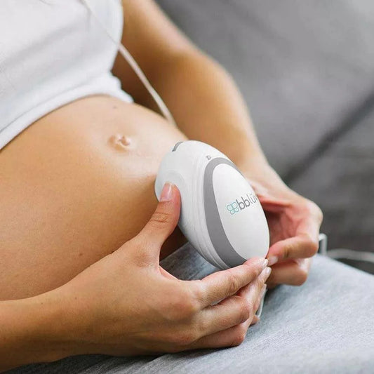 Várandós nő hasán tartja a babaszívószívó készüléket, légzésfigyelő funkcióval